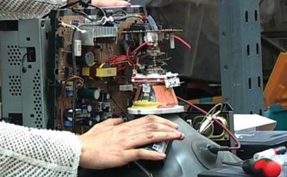EIA investigator installing a tracking device in a broken monitor to follow illegal e-waste shipments (c) EIA