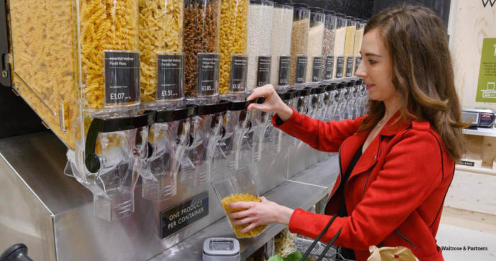 A shopper in Waitrose filling a reusable container with pasta
