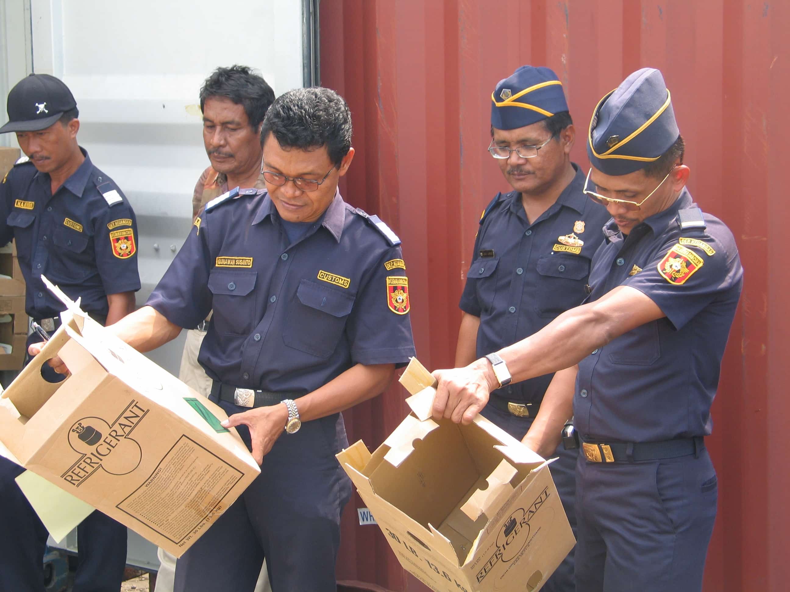 "Indonesian customs officers inspecting a shipment of illegal ozone-depleting chemicals"